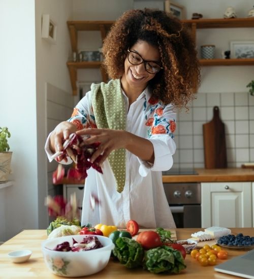 A woman preparing a healthy meal with fresh vegetables in her kitchen